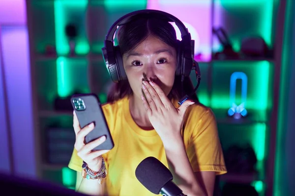 Китайская Девушка Играет Видеоигры Смартфоном Прикрывая Рот Рукой Шокирована Боится — стоковое фото