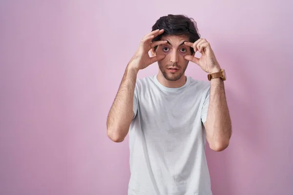 Молодой Латиноамериканец Стоящий Розовом Фоне Пытается Открыть Глаза Пальцами Сонный — стоковое фото
