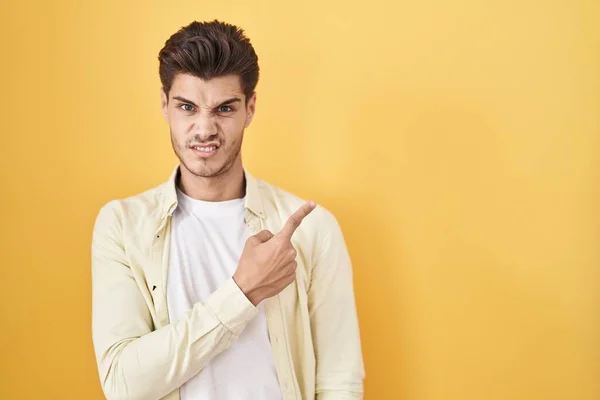 Young Hispanic Man Standing Yellow Background Pointing Aside Worried Nervous — Stock Fotó