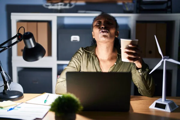 Mujer Africana Trabajando Con Computadora Portátil Noche Mirando Cámara Soplando —  Fotos de Stock