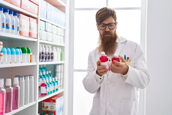Young Redhead Man Pharmacist Holding Medication Bottle Pharmacy — Stock Photo, Image