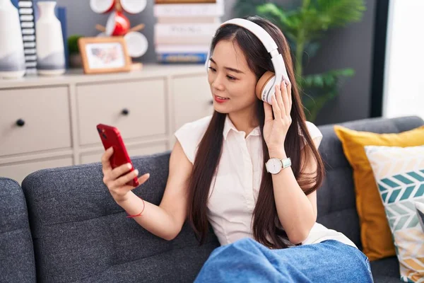 Молодая Китаянка Слушает Музыку Сидя Дома Диване — стоковое фото