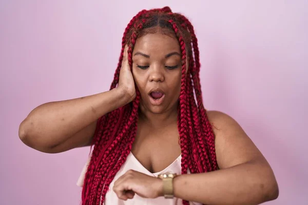Африканская Американка Плетеными Волосами Стоящая Розовом Фоне Глядя Часы Беспокоясь — стоковое фото