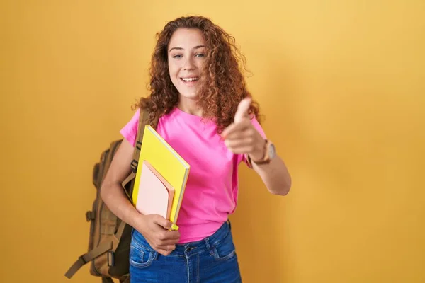 Young Caucasian Woman Wearing Student Backpack Holding Books Pointing Fingers — Stock Photo, Image