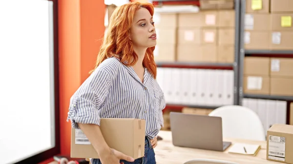 Genç Kızıl Saçlı Kadın Kadını Ofiste Bir Paket Tutuyor — Stok fotoğraf