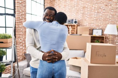 Erkek ve kadın çift yeni evlerinde birbirlerine sarılıyorlar.