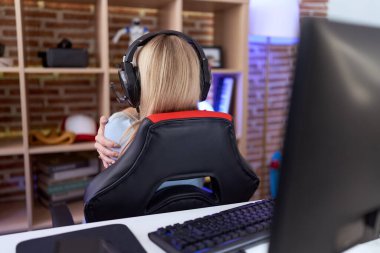 Video oyunları oynayan, kulaklık takan, kendine sarılan, mutlu ve pozitif bir genç beyaz kadın. Sevgi ve özgüven. 