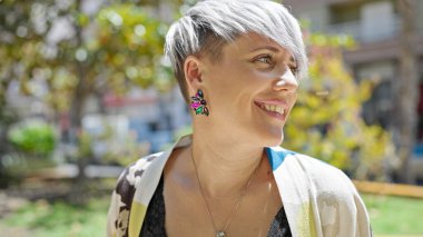 Young woman smiling confident looking to the side at park