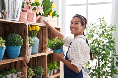 Çiçekçide çiçek taşıyan güzel bir İspanyol kadın.