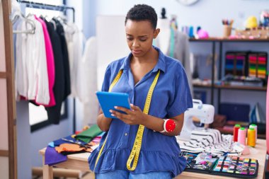 Terzi dükkanında dokunmatik ped kullanan Afrikalı Amerikalı kadın terzi.