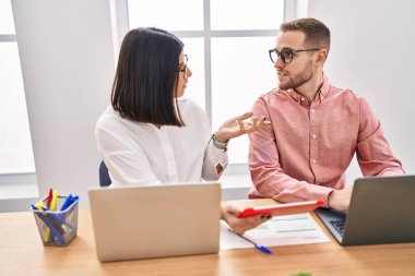 Ofiste çalışan erkek ve kadın işçiler dizüstü bilgisayar ve dokunmatik ped kullanıyorlar.