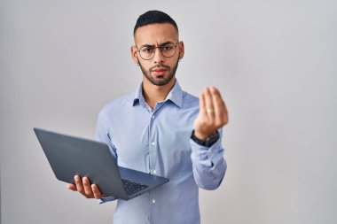 Bilgisayarda çalışan İspanyol genç adam İtalyanca jestler yapıyor. El ve parmaklar kendinden emin ifade ediyor. 