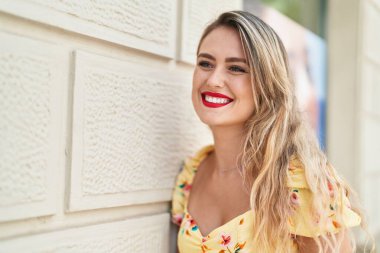 Young beautiful hispanic woman smiling confident looking to the side at street