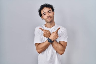 İzole edilmiş arka planda duran İspanyol adam iki tarafı da parmaklarıyla işaret ediyor. Farklı yönler farklı. 