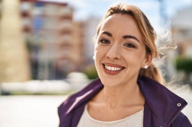 Sokakta kendinden emin gülümseyen genç bir kadın