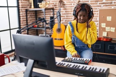 Afrikalı Amerikalı kadın müzisyen müzik stüdyosunda DJ seansı yapıyor.