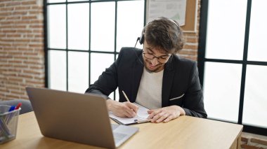 Genç Arap iş adamı bürodaki belgeye video mesajı yazdırıyor.