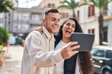 Man and woman smiling confident using touchpad at street