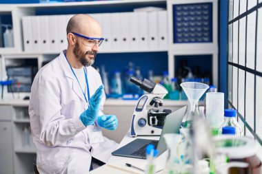 Genç kel bilim adamı laboratuarda video görüşmesi yapıyor.