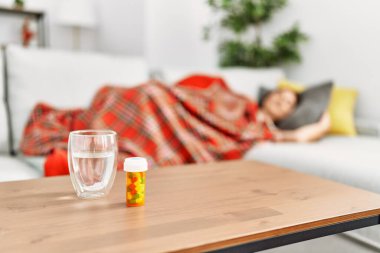 Young beautiful hispanic woman lying on sofa sleeping at home