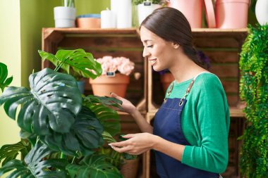 Çiçekçide kendine güvenen güzel İspanyol kadın çiçekçi.