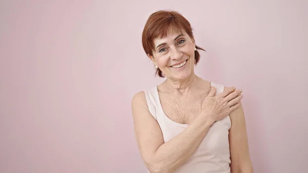 Volwassen Latino Vrouw Aanraken Schouder Glimlachen Geïsoleerde Roze Achtergrond — Stockfoto
