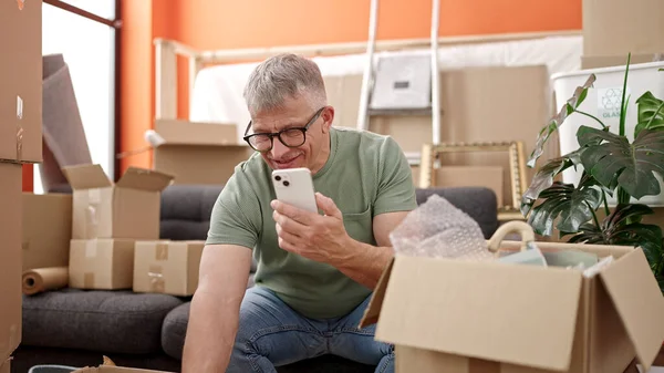 Homem Cabelos Grisalhos Meia Idade Desembalando Caixa Papelão Usando Smartphone — Fotografia de Stock