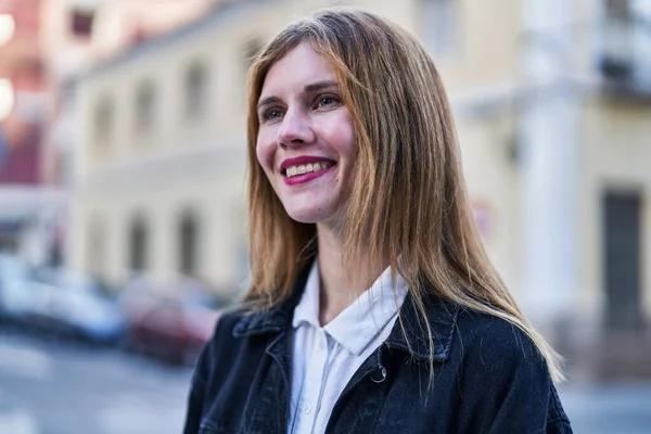 Young blonde woman smiling confident looking to the side at street