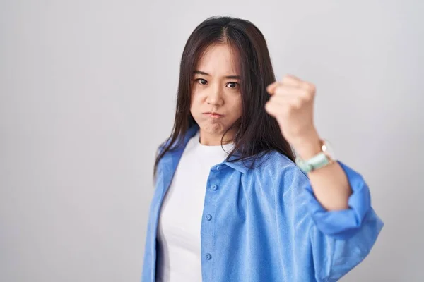 怒って怒って怒って白い背景の上に立っている若い中国人女性と怒って叫びながら拳不満と激怒を上げる 怒りと攻撃的な考え方 — ストック写真