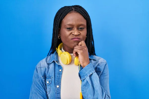 Mavi Arka Planda Dikilmiş Örgü Ören Afrikalı Kadın Çenesinde Parmak — Stok fotoğraf