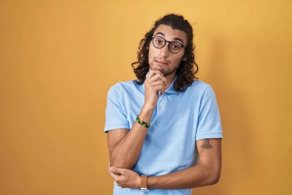 Ung Latinamerikansk Man Står Över Gul Bakgrund Tänker Orolig För — Stockfoto