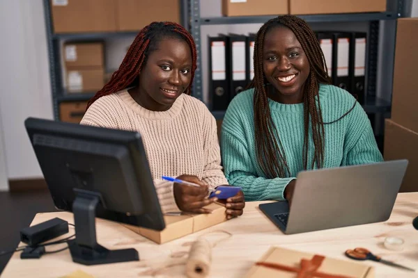アフリカ系アメリカ人女性は オフィスでノートパソコンやクレジットカードを使用してビジネスワーカーをEコマース — ストック写真