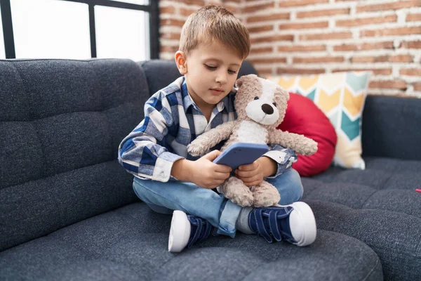 Adorable Caucasian Boy Hugging Teddy Bear Using Smartphone Home — Stock Photo, Image