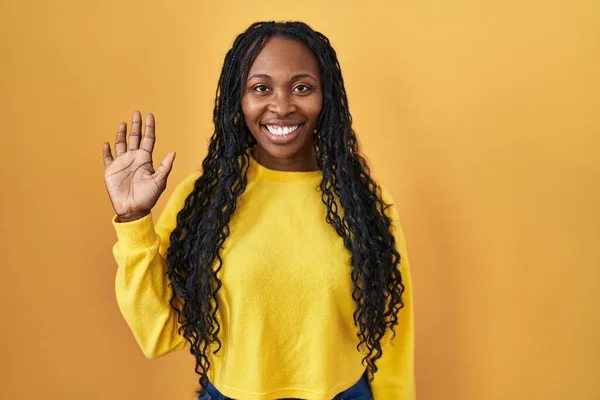 Африканська Жінка Стоїть Над Жовтим Фоном Показуючи Вказуючи Вгору Пальцем — стокове фото