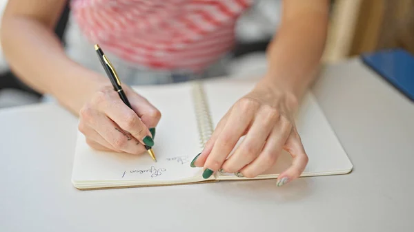 Junge Blonde Frau Sitzt Auf Tisch Und Schreibt Auf Notizbuch — Stockfoto