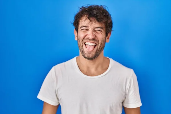 Hispanic Young Man Standing Blue Background Sticking Tongue Out Happy — Stock Photo, Image