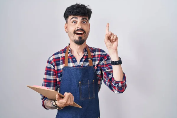 Young Hispanic Man Beard Wearing Waiter Apron Holding Clipboard Pointing — Stock Photo, Image