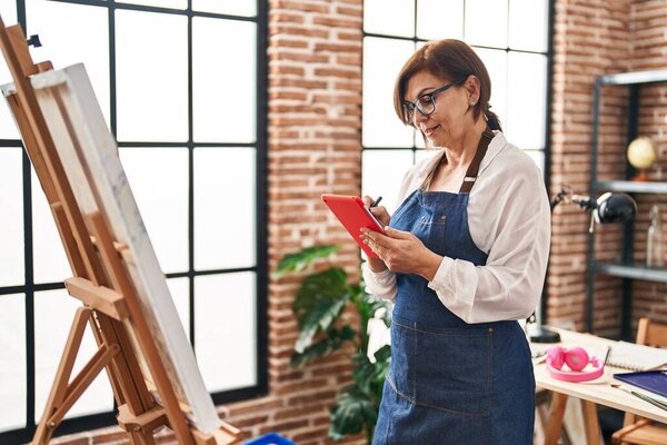 Женщина средних лет использует тачпад-рисунок в художественной студии