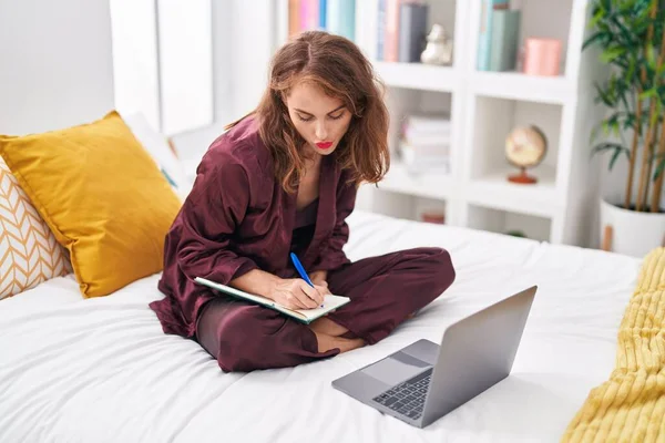 Junge Schöne Hispanische Frau Mit Laptop Schreiben Auf Notizbuch Schlafzimmer — Stockfoto