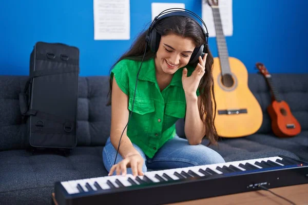 若いヒスパニック系の女性音楽家が音楽スタジオでピアノキーボードを演奏 — ストック写真