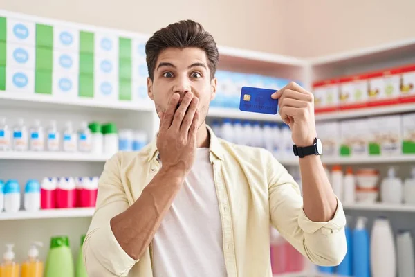Νεαρός Ισπανός Στο Φαρμακείο Κρατώντας Πιστωτική Κάρτα Που Καλύπτει Στόμα — Φωτογραφία Αρχείου
