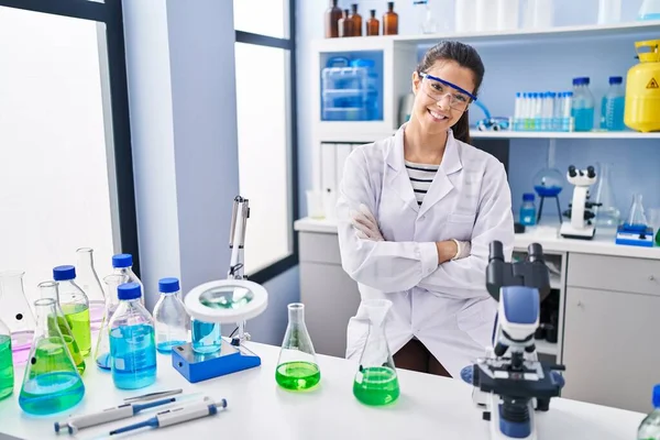 아름다운 과학자가 자신있게 미소짓고 실험실에서 제스처를 가로지를 — 스톡 사진