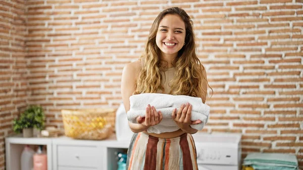 Mladá Krásná Hispánská Žena Usměvavá Sebevědomě Drží Složené Ručníky Prádelně — Stock fotografie