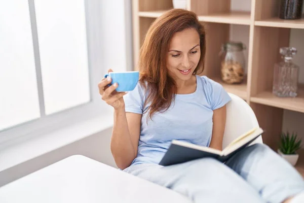 Молодая Женщина Читает Книгу Пьет Кофе Дома — стоковое фото