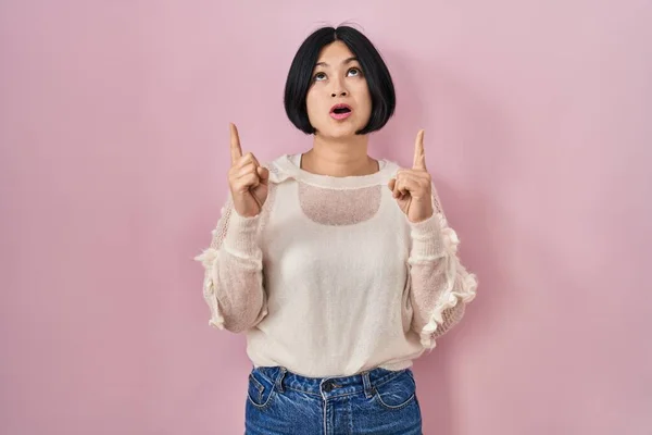 Ung Asiatisk Kvinna Står Över Rosa Bakgrund Förvånad Och Förvånad — Stockfoto