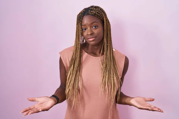 Африканская Американка Плетеными Волосами Стоящая Розовом Фоне Невежественная Смущенная Открытыми — стоковое фото
