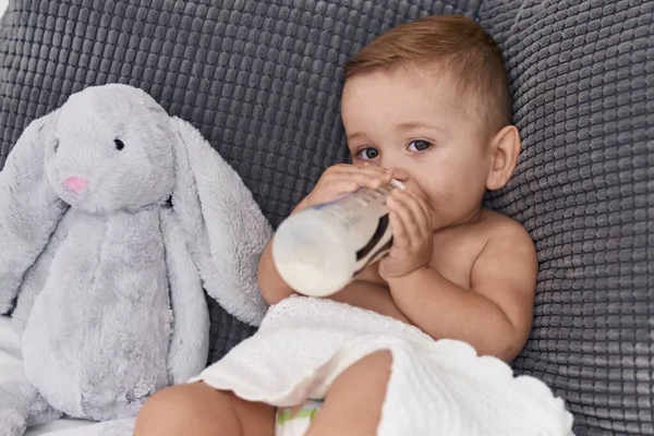 Urocze Dziecko Rasy Kaukaskiej Ssące Mleko Butelce Karmienia Siedząc Kanapie — Zdjęcie stockowe