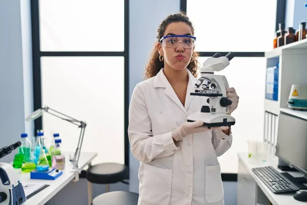 Young Hispanic Woman Working Scientist Laboratory Puffing Cheeks Funny Face — ストック写真
