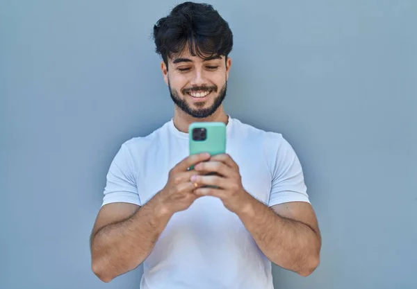 Young Hispanic Man Smiling Confident Using Smartphone White Isolated Background — Zdjęcie stockowe