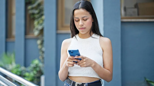 Mujer Hispana Hermosa Joven Usando Teléfono Inteligente Con Expresión Seria —  Fotos de Stock